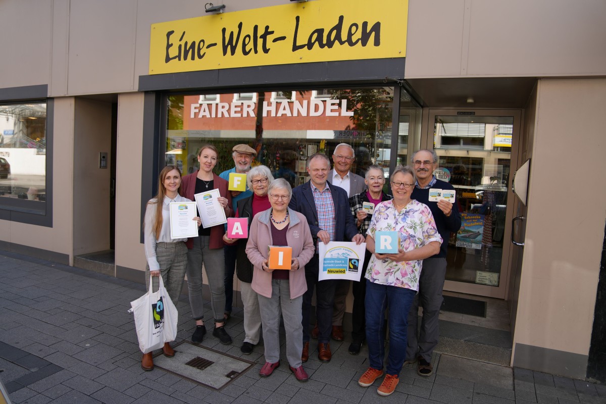Vor dem Eine-Welt-Laden in der Neuwieder Innenstadt freuen sich Landrat Achim Hallerbach, Oberb�rgermeister Jan Einig, die Steuerungsgruppe der Fairtrade-Stadt Neuwied sowie Ehrenamtliche des Eine-Welt-Ladens �ber die Aktionen in der Fairen Woche. (Foto: Nadine Sch�neberg/Stadtverwaltung Neuwied)