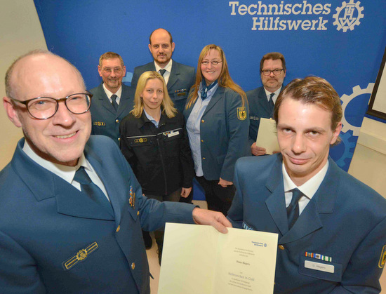 Das Helferzeichen in Gold wurde an THW-Helfer Dennis Hegers (rechts) verliehen. Die Auszeichnung nahm Regionalstellenleiter Christian Wrker (links) vor. Weitere Geehrte und Ortsbeauftragter Ulrich Weber (hinten, links) stellten sich mit auf. Foto: (tt)