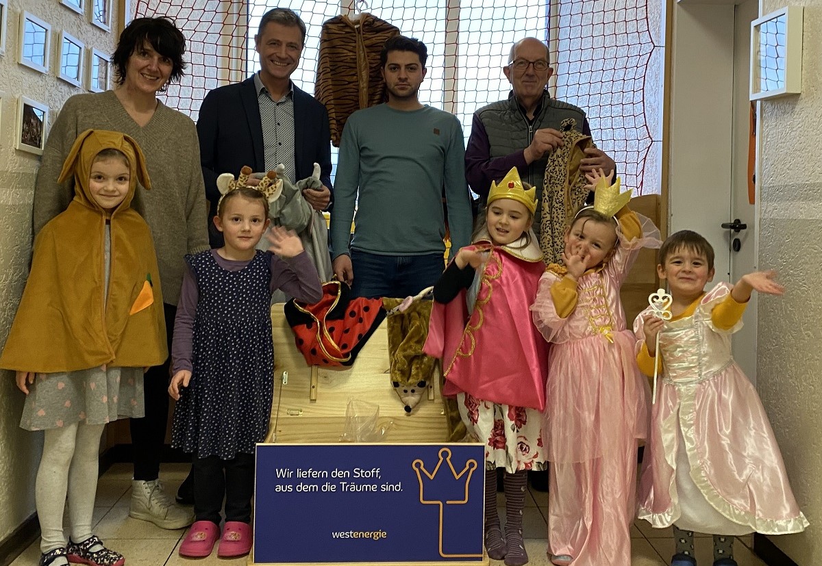 Kathrin Heine (l.), Peter Imhuser(2.v.l.) und Michael Wschenbach (r.) mit begeisterten Kindern bei der bergabe der Westenergie-Theaterkiste im Kindergarten Zauberwald.