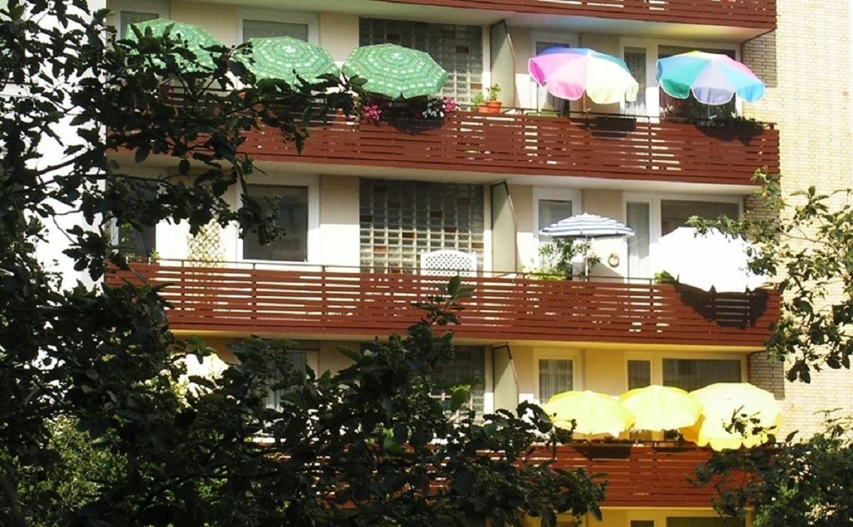 Auf dem Balkon verschafft ein geffneter Sonnenschirm den Fensterflchen Schatten. (Foto: Hermann Obermeyer)
