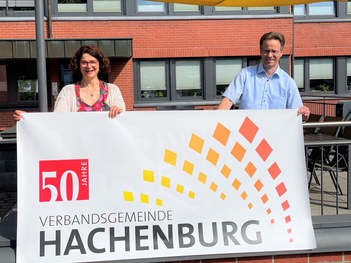 Brgermeisterin Gabriele Greis und der erste Beigeordnete der Verbandsgemeinde Hachenburg stellen den Jubilumsbanner vor. (Foto: Verwaltung Hachenburg)