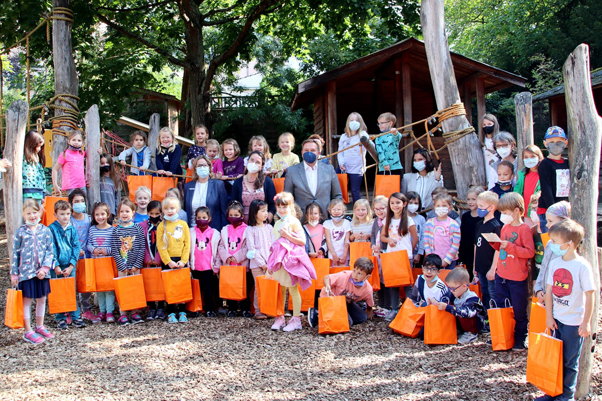 Fast alle Kinder aus den ersten Klassen der Schule Am Reichenberg mit den Erwachsenen (in der Mitte  v. l. ): Stefanie Galvao de Brito (Volksbank Kln Bonn eG), Stephanie Eichhorn (Leiterin der Stadtbcherei), Erster Beigeordneter Holger Heuser und (ganz rechts) Schulleiterin Nicola Kiwitt. Foto: Stadt Bad Honnef