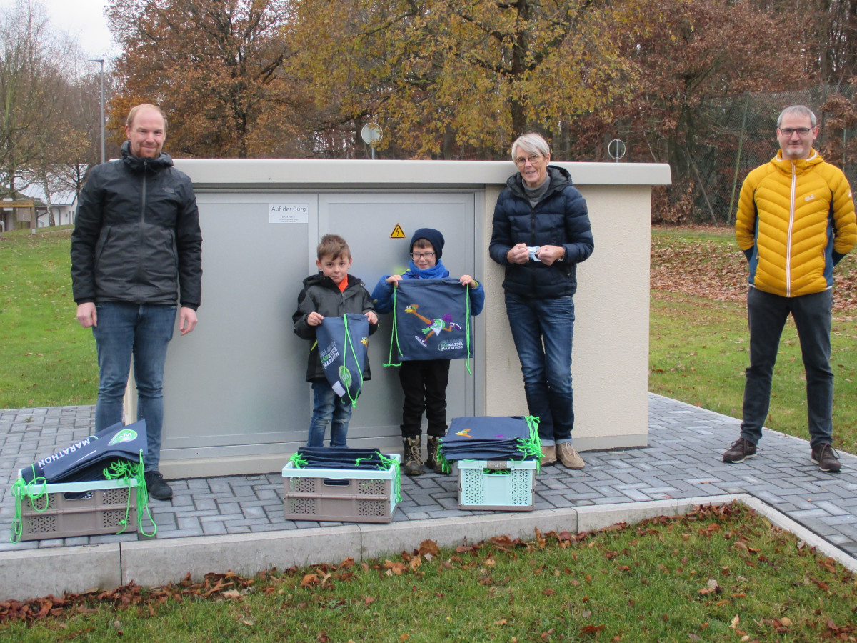 Johannes Rudolph von der EAM (links) bergibt Sportbeutel und Halstcher an Uron und Paul von der Kita Burgmuse (2. und 3. v.l.). Mit dabei: Kita-Leiterin Angela Koch (2. v.r.) und Gemeinderatsmitglied Thomas Schug (rechts). (Foto: EAM)