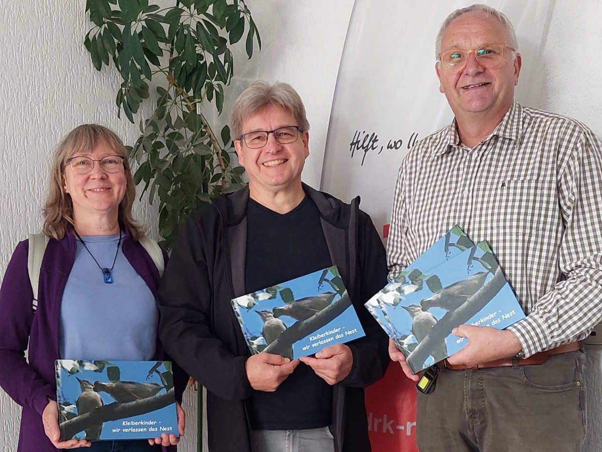 Die Eheleute Meister �berreichten J�rg Gerharz (rechts) die Kinderbuchspende (Foto: Andrea Ebach/DRK KV AK)