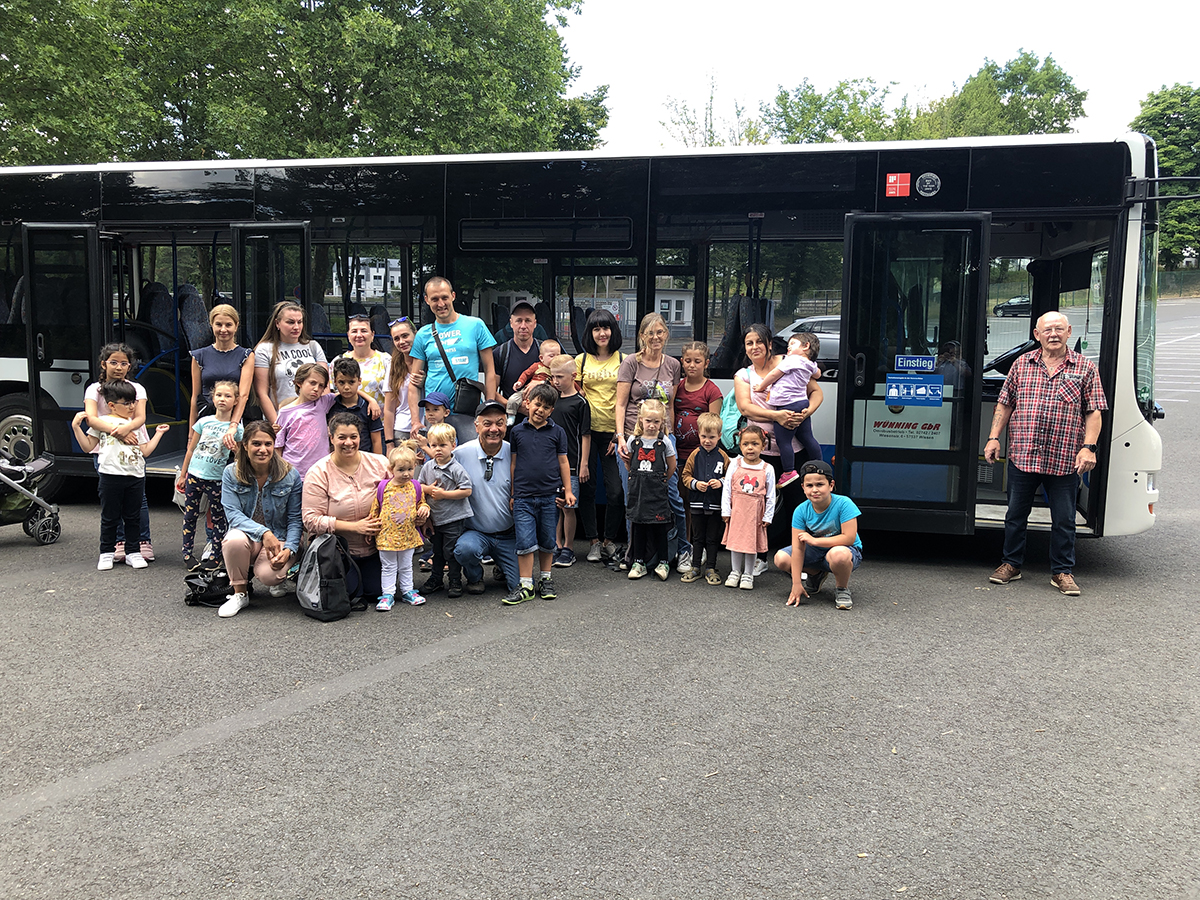 Unten links: Sabah Bayar, Vorsitzende des Migrationsbeirats mit einigen Teilnehmerinnen und Teilnehmern des Ausflugs in den Tierpark sowie dem Busfahrer der Fa. Wnning, Bernd Hassel. Foto: Privat