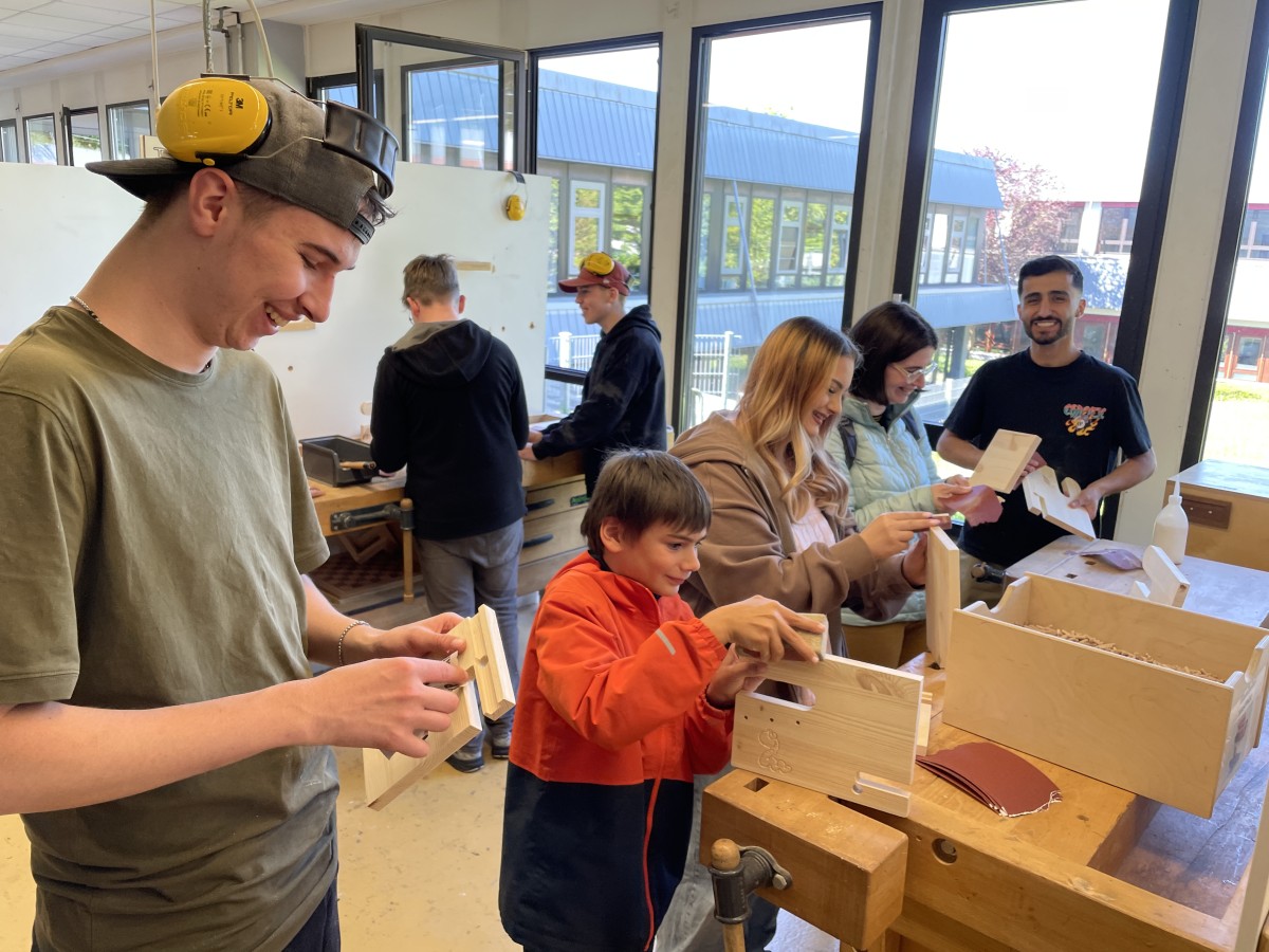 Ein Auszubildender im Handwerkerzentrum des Heinrich-Hauses fertigt mit den Gsten ein Schlsselbrett und Handy-Halter aus Holz an. (Foto: Julia Steffenfauseweh)