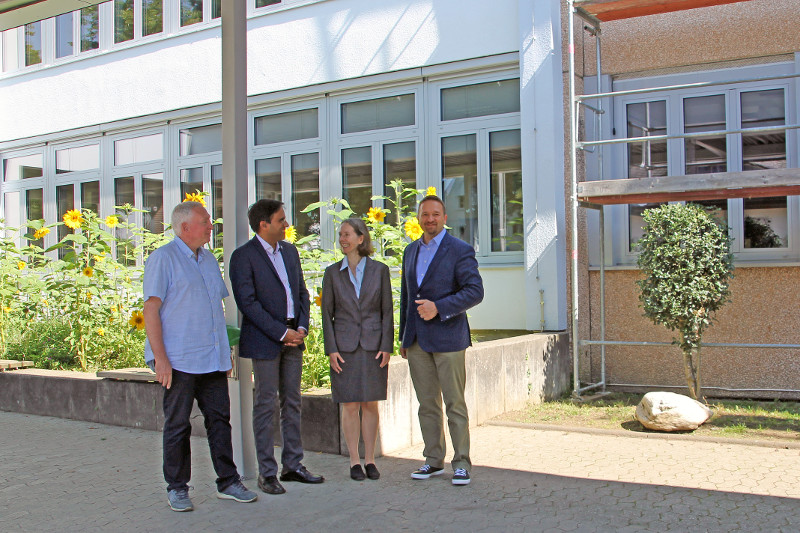 Zu sehen sind im Hintergrund die neuen Fenster des Stdtischen Siebengebirgsgymnasiums - das Gerst fr den Einbau steht noch - v. l.: Architekt Klaus Niehoff, Fabiano Pinto (Geschftsbereichsleiter Stdtebau), Schulleiterin Dr. Gabriele Jacob, Erster Beigeordneter Holger Heuser. Foto: Stadt Bad Honnef