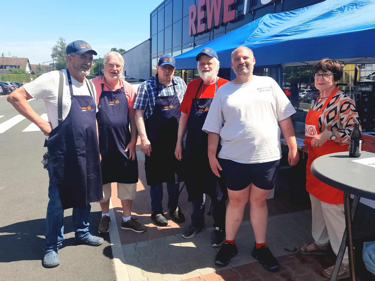 Die Wissener Tafeln boten vor einem heimischen Einkaufszentrum leckere Bratwurst und Getr�nke an. Auf dem Bild sind einige der ehrenamtlichen Helfer mit einem Kunden (Zweiter von rechts) zu sehen. (Foto: Bernhard Theis)