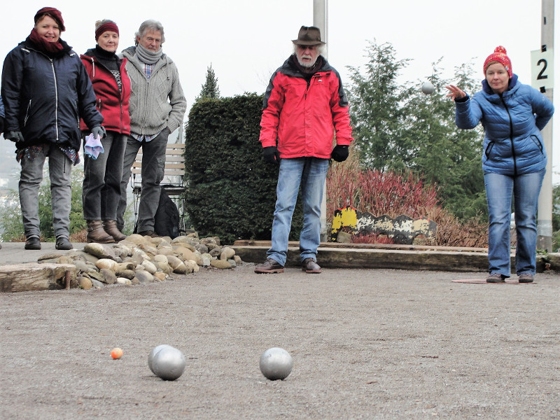 Unter den kritischen Augen der Konkurrenz versucht die Spielerin von Siegen aux boules die eigene Kugel zu platzieren. Foto: Privat