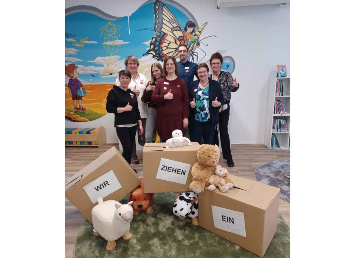 Stolz pr�sentiert das Team der Stadtbibliothek mit (v.l.) Diane M�ller-Lopez, Susanne Walter-Hahn, Luisa Merz, Carina Senko, Lukas Wilhelmi, Klaudia Zude und Ursula Kingen die leeren Umzugskartons. Im Hintergrund das Wandgem�lde von "Dater127". (Fotos: VG Montabaur/Christina Wei�)