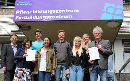 Mit den Schlern des Pflegebildungs- und Fortbildungszentrums der Diakonie in Sdwestfalen an der Virchowstrae freuen sich der Leiter des Qualittsmanagements Sebastian Schreiber (links), Qualittsbeauftragte Andrea Wolf (2. von links) und Schulleiter Frank Fehlauer (rechts) ber die Zertifizierung der Bildungssttte. (Foto: Diakonie in Sdwestfalen)