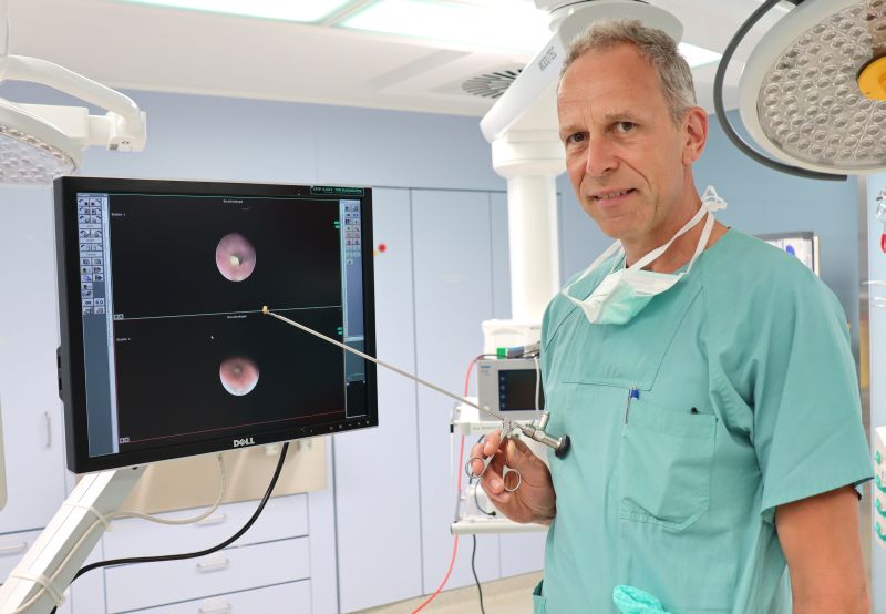 Chefarzt Dr. Rainer Blickheuser im OP mit Endoskop sowie entsprechendem Befund nach Aspiration einer Nuss. Foto: Siegener Kinderklinik