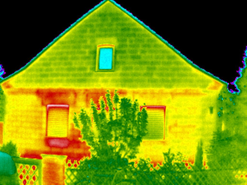 Im Wärmebild lässt sich erkennen, dass über Rollladenkästen und Fensterbänke der linken Haushälfte viel Wärme nach draußen gelangt (im Bild rot gefärbt). 
Foto: Verbraucherzentrale Rheinland-Pfalz e.V.
