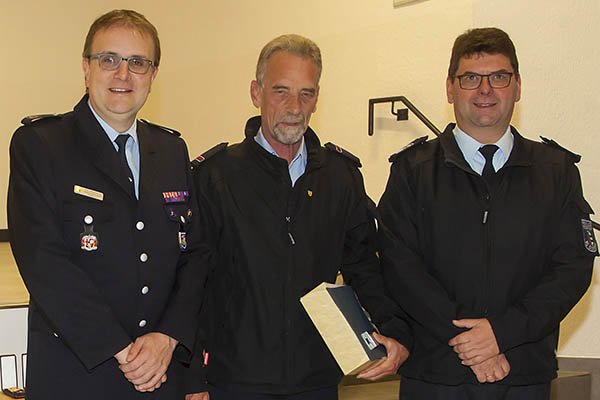 Dirk Elberskirch (links) verlieh Dieter Gassen (Mitte) die Ehrennadel des Feuerwehrverbandes. Als erstes gratulierte Wehrleiter Andreas Schmidt (rechts). Foto: Feuerwehr VG Dierdorf
