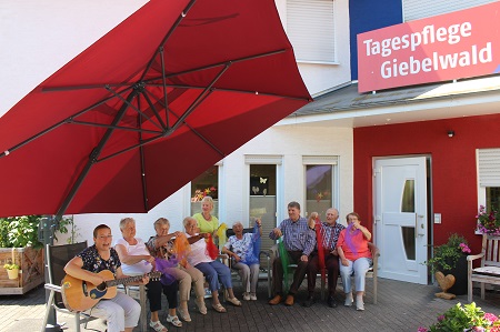 Perfekt abgeschirmt vor der Sommerhitze sind die Senioren der Tagespflege Giebelwald in Kirchen. (Foto: Tagespflege Giebelwald)