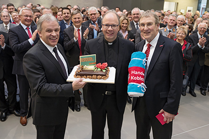 
Bischof Stephan Ackermann erhlt von Kurt Krautscheid (links) und Hauptgeschftsfhrer Alexander Baden (rechts) eine Torte mit dem Slogan der Imagekampagne des Handwerks Am Anfang waren Himmel und Erde. Den ganzen Rest haben wir gemacht. Foto: P!ELmedia