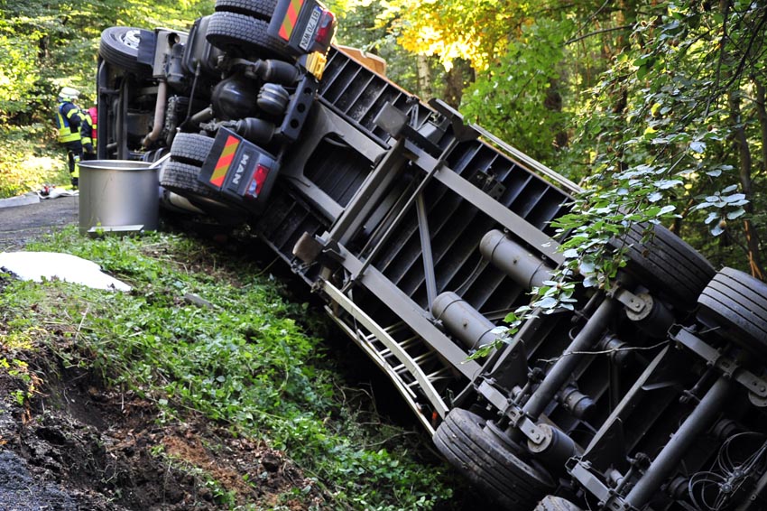 Holztransporter kippt im Wald um, Diesel droht auszulaufen