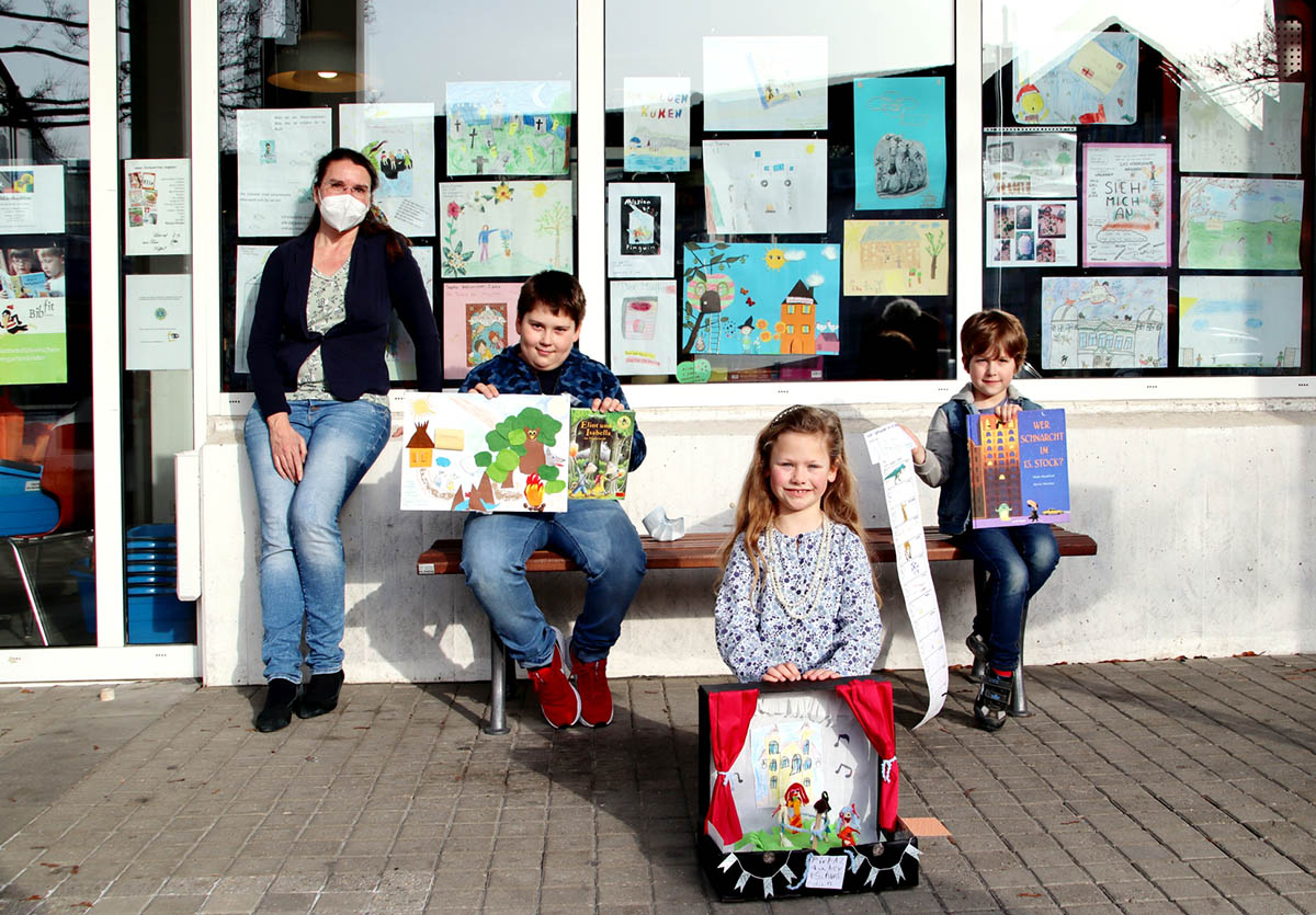 Vor der Fensterausstellung in der Stadtbcherei im Rathaus  v. l.: Leiterin Stephanie Eichhorn sowie Vladim (9), Liana (7) und Mats (5) mit ihren Werken fr den Wettbewerb. Foto: Stadt Bad Honnef