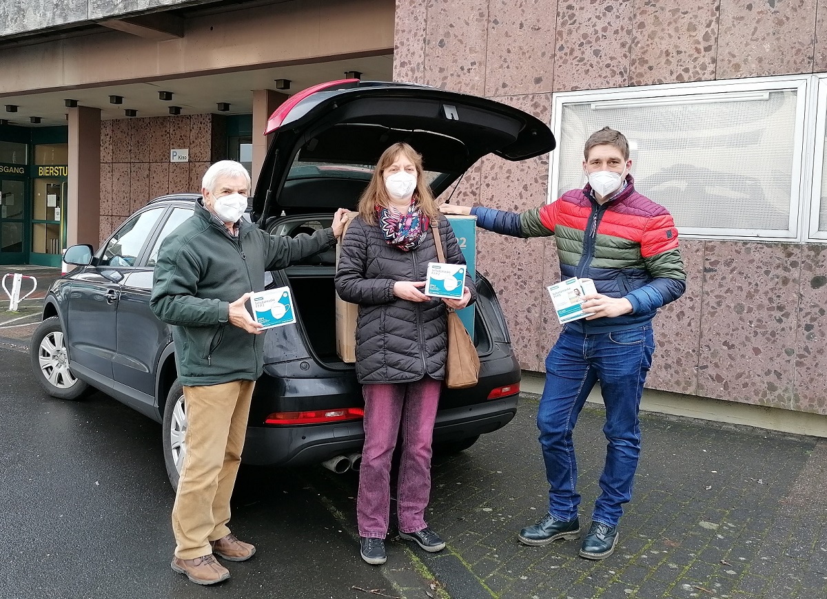 Wolfgang Fricke (SPD-Ortsvereinsvorsitzender) berreicht Matthias Gibhardt und Christa Abts die Masken zur Verteilung (Foto: Caritasverband Altenkirchen)