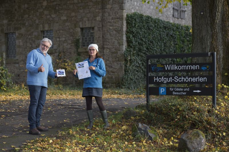 Katharina Kindgen vom NABU Montabaur, die Christoph Kopper vom Campingpark Hofgut-Schnerlen eine Fledermausplakette im Rahmen des Projektes Fledermuse willkommen verleiht. Foto: Marc Kopper