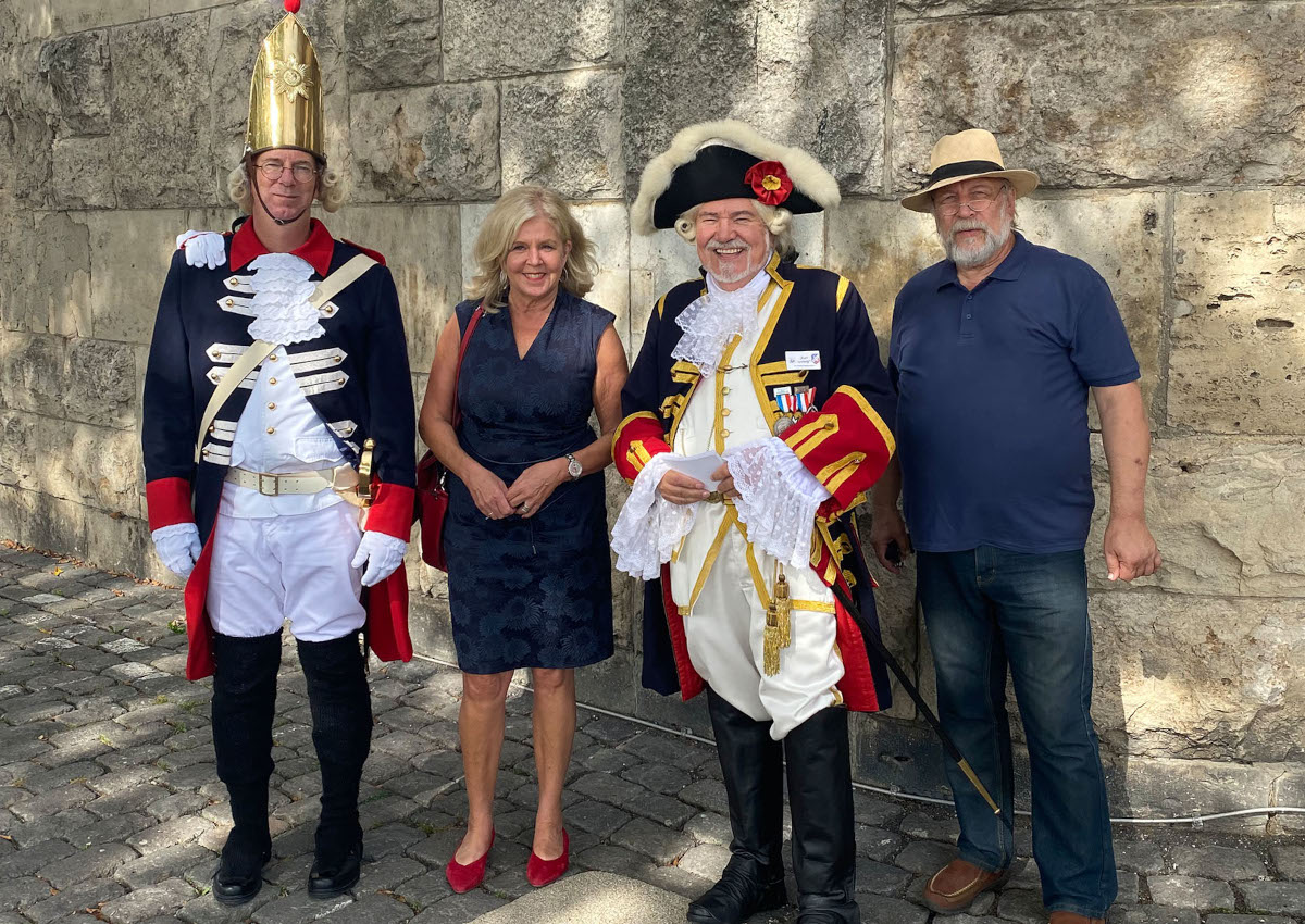 vhs-Leiterin Jutta Gnther mit (von links) Manfred Wertgen, Robert Raab und Michael Krmer von der Ehrengarde Neuwied vor der Deichmauer. (Foto: Stadt Neuwied)