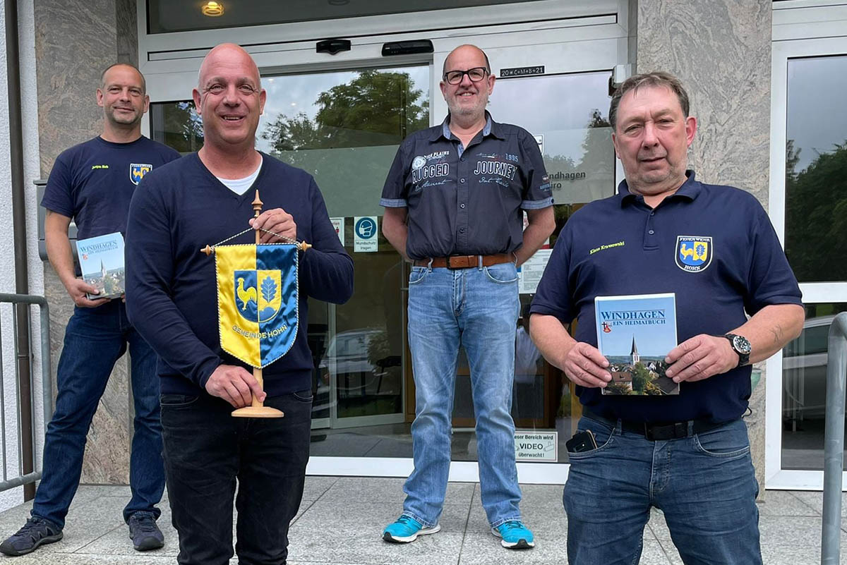 Von links: Jrgen Sieh, Martin Buchholz, Hans Dieter Geiger, Klaus Krassowski vor dem Gemeindebro in Windhagen beim Austausch von Wimpel der Gemeinde Hohn gegen Heimatbcher der Ortsgemeinde Windhagen. Foto: privat
