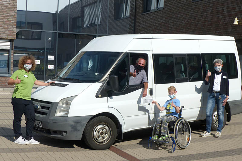 Schler verteilen Masken an ihre Busfahrer