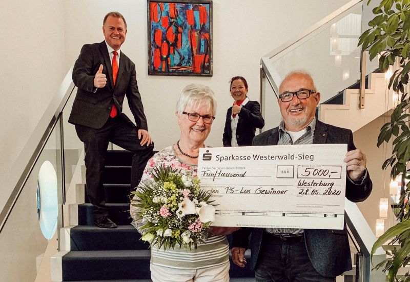 Jasmin Stiltz, Leiterin der Geschftsstelle Westerburg, und Kundenberater Christoph Speicher berreichen den Eheleuten Ferger sinnbildlich einen Scheck ber 5.000 Euro. Foto: Sparkasse