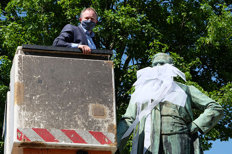 Oberbrgermeister Jan Einig legte selbst Hand an, um dem Raiffeisen-Denkmal einen Mund-Nasen-Schutz anzulegen. Fotos: Stadt Neuwied