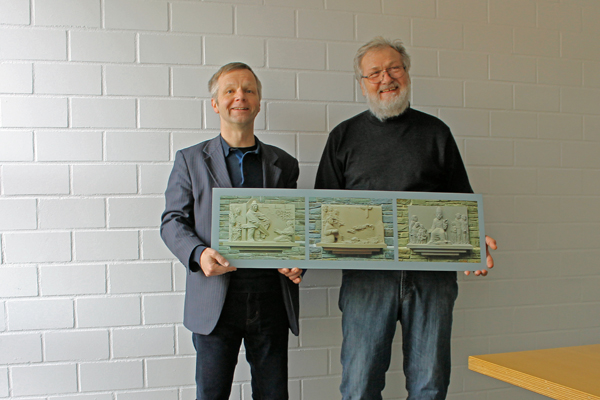 Bildhauer Titus Reinarz (rechts) bergab Brgermeister Otto Neuhoff (links) ein Schild mit den Fotos der drei Reliefs ber das Leben des Heiligen Martin, die in der Selhofer Kirche St. Martin angebracht sind. Foto: Privat