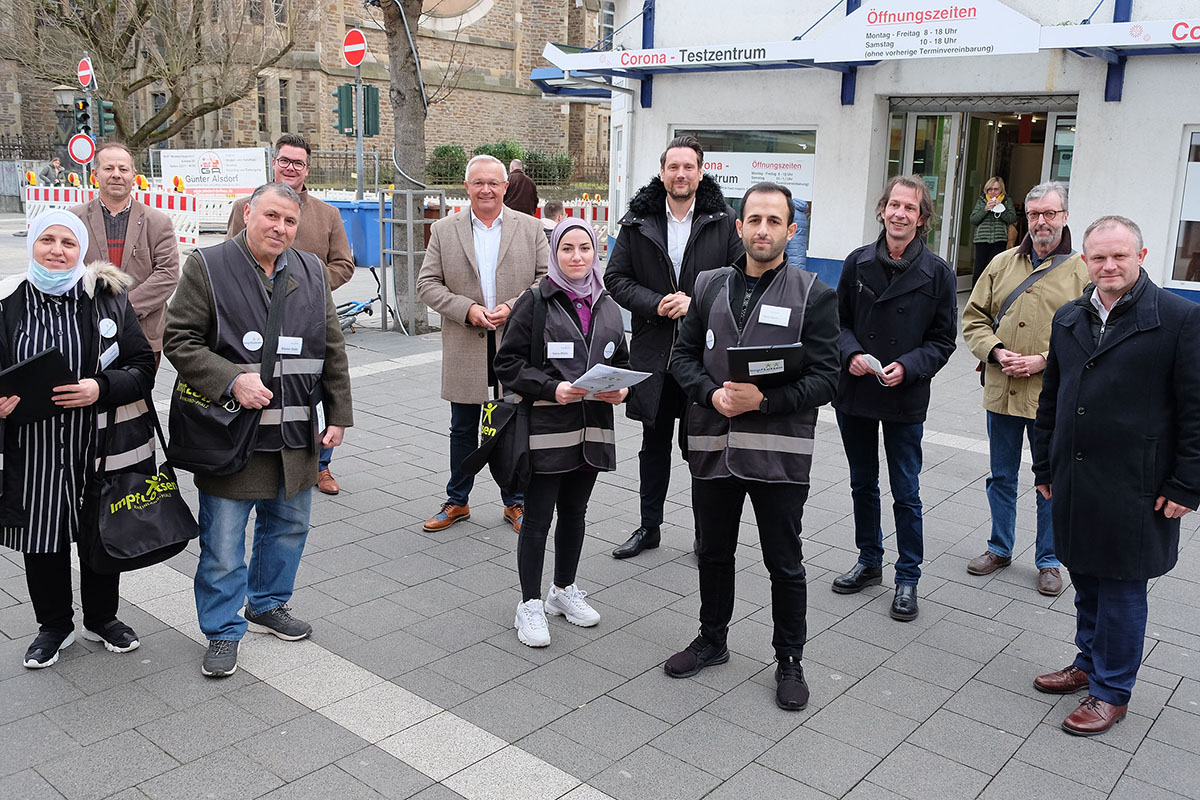 Dr. Matthias Krell, Geschftsfhrer der Landeszentrale fr Gesundheitsfrderung (hinten, rechts), und Daniel Stich, Ministerialdirektor im Ministerium fr Wissenschaft und Gesundheit (hinten, 3. von rechts), besuchten gemeinsam mit Oberbrgermeister Jan Einig (vorne, rechts), Brgermeister Peter Jung (hinten, 2. von links), Landrat Achim Hallerbach (hinten, 3. von links) und Eirene-Pressesprecher Thorsten Klein (3. von rechts) die Impflotsen beim Einsatz in der Neuwieder Innenstadt. Foto: Stadt Neuwied