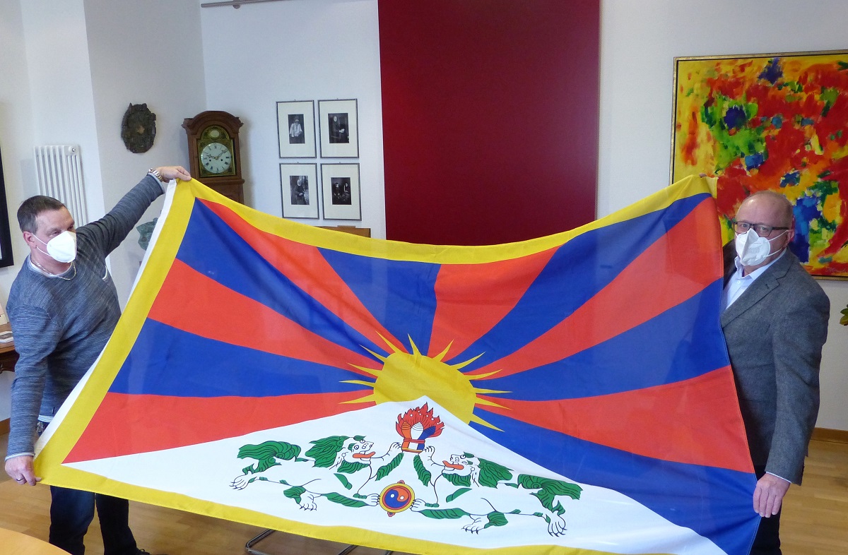 Landrat Dr. Peter Enders (rechts) und Hausmeister Rainer Scherm von der Kreisverwaltung mit der Tibet-Flagge, die zum Jahrestag des tibetischen Volksaufstandes von 1959 wieder am Kreishaus in Altenkirchen gehisst wird. (Foto: Kreisverwaltung)  