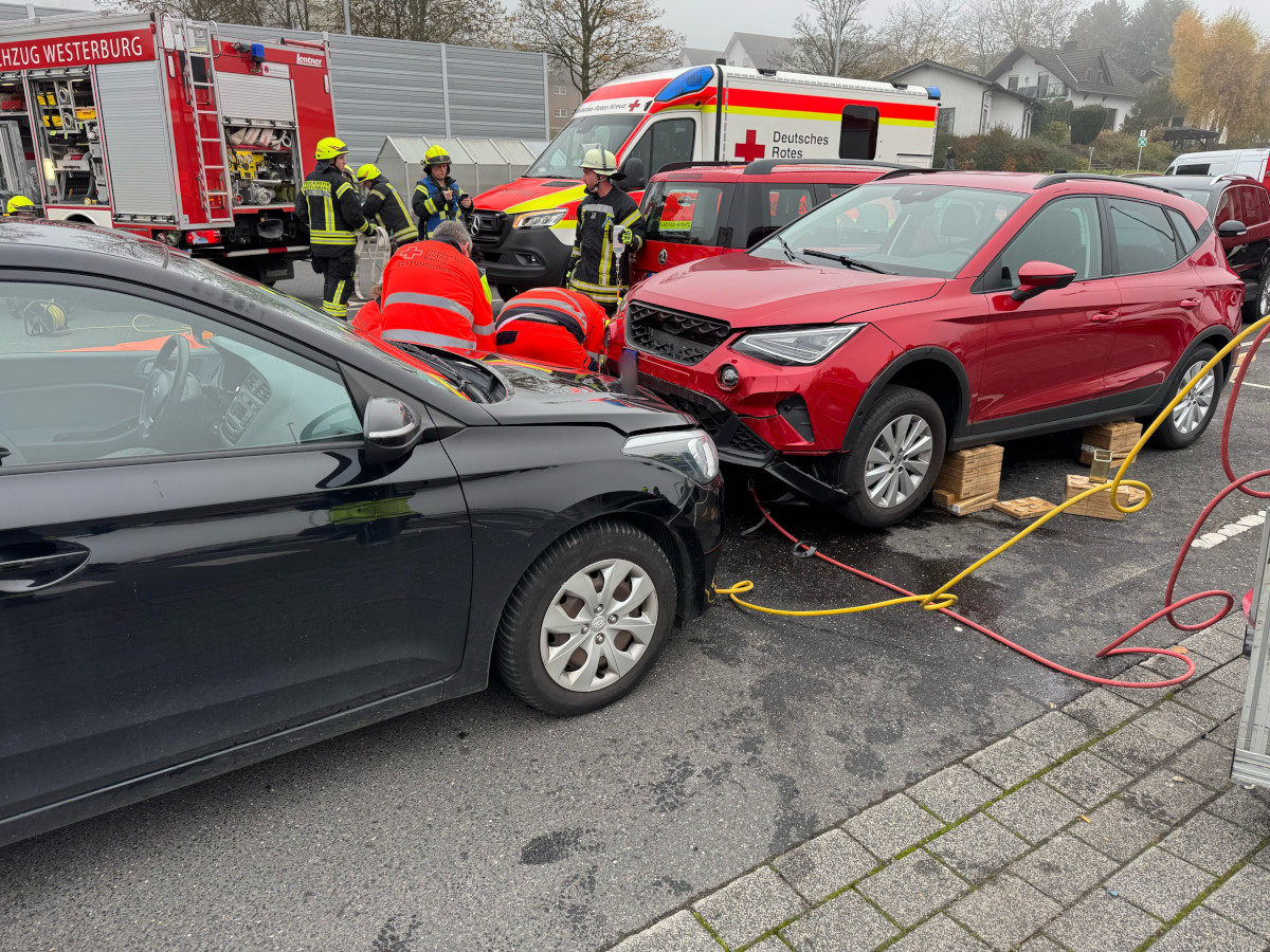 Frau auf Supermarktparkplatz in Westerburg unter Pkw eingeklemmt