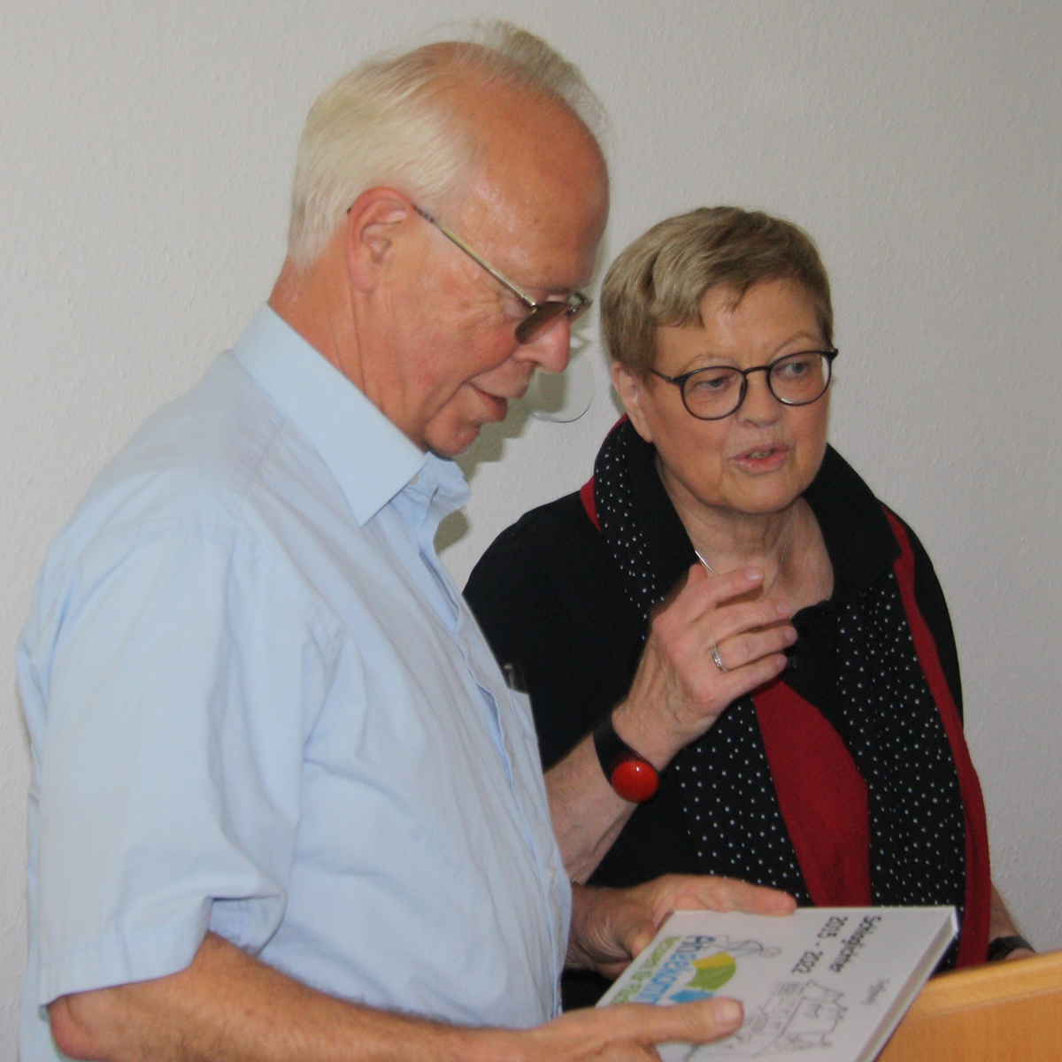Zum Abschied berreichte die Beigeordnete der Verbandsgemeinde und Koordinatorin der Ehrenamtsprojekte der Verbandsgemeinde, Eva Ehrlich-Lingens (rechts) Michael Schwarzer das Foto-Buch Schlaglichter, das die Arbeit des Netzwerkes Angekommen dokumentiert. Foto: Privat
