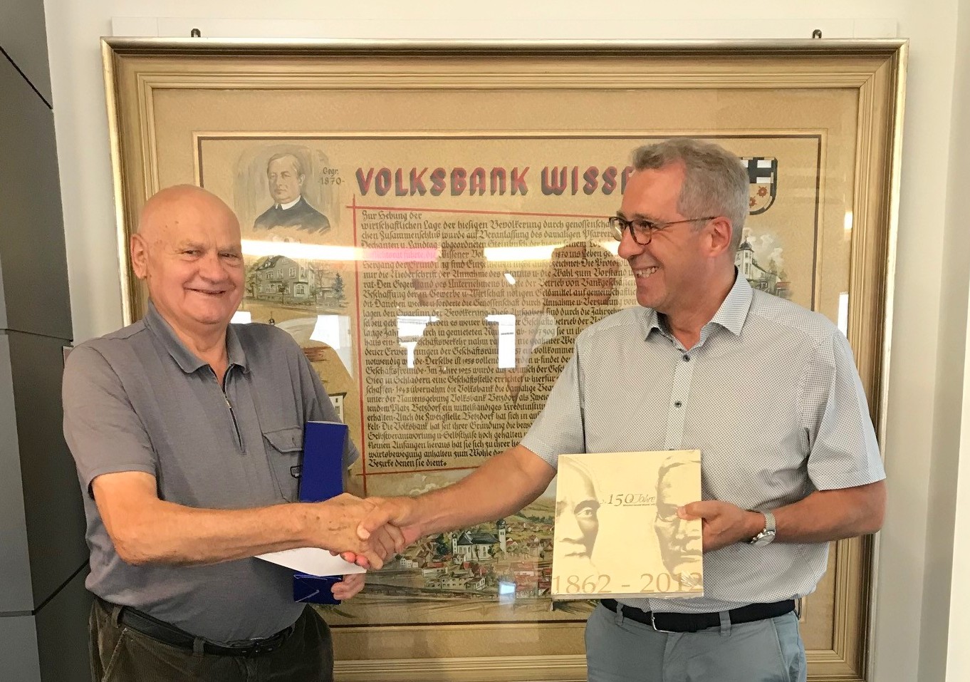 Marktbereichsleiter Georg Rdder (rechts) von der Westerwald Bank in Wissen gratuliert Bernhard Henn zum Jubilum. (Foto: Westerwald Bank)