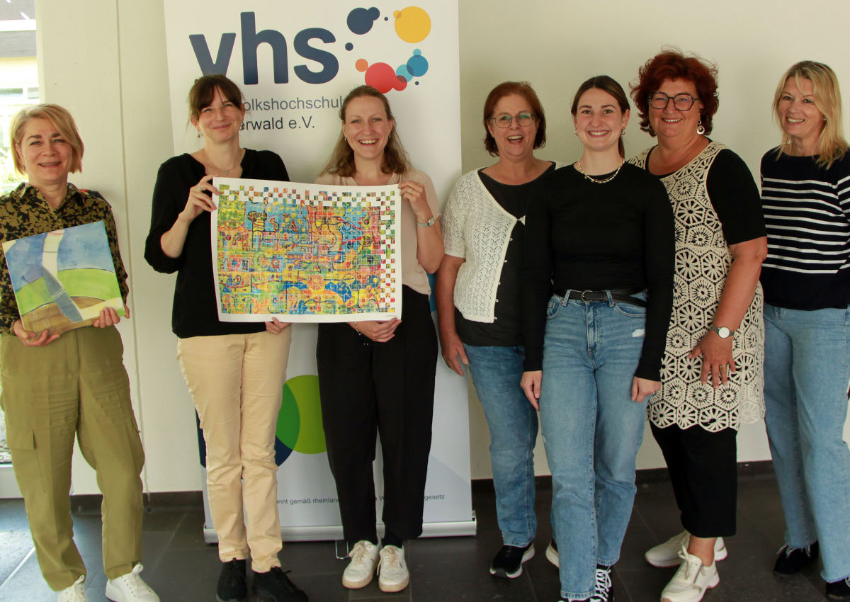 Gutachterin Judith Granzow bergibt dem Team der Kreis-vhs die Kachel, die sie als Teil im LQW-Netzwerkbild darstellt. (Kreisverwaltung / Carolin Faller)