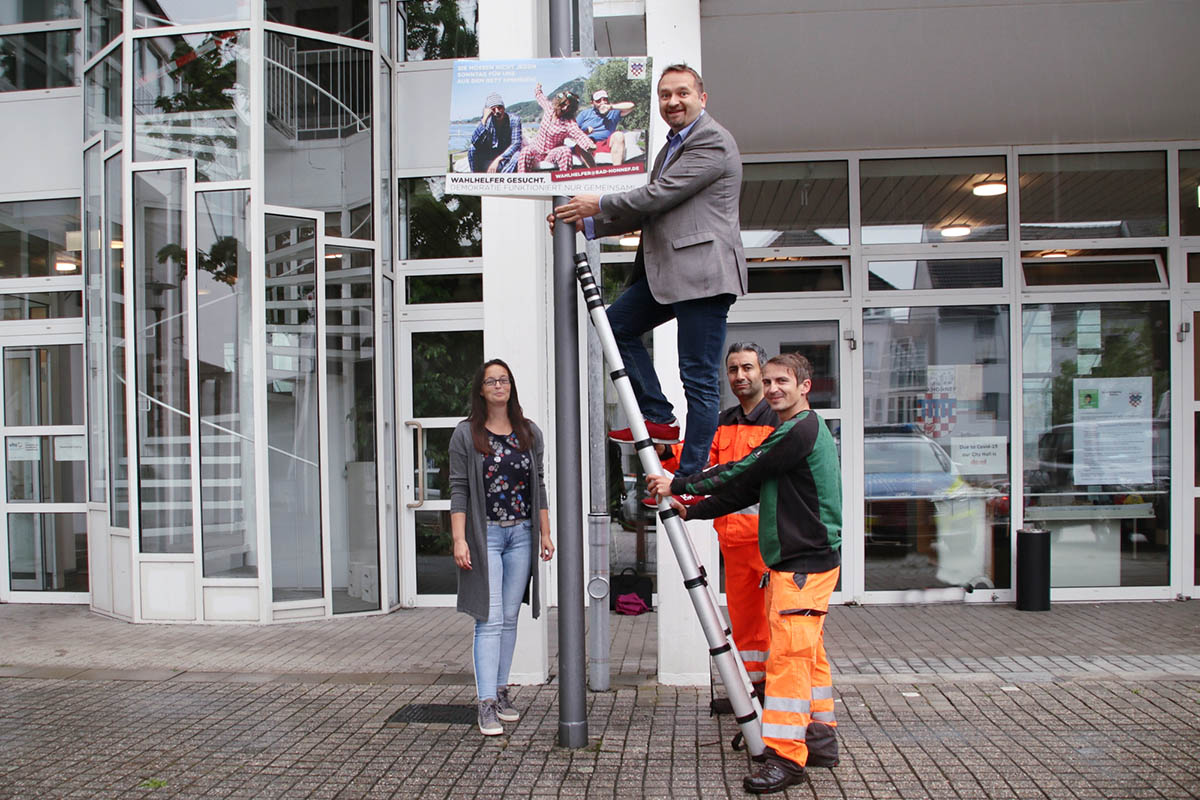 Auch auf dem Rathausplatz stieg Erster Beigeordneter Holger Heuser auf die Leiter, um die Wahlhelferplakate aufzuhngen - v. l. von der Stadt Bad Honnef: Simone Walterscheidt, Erster Beigeordneter Holger Hauser, Ahmad Khder und Andreas Tix. Foto: Stadt Bad Honnef.