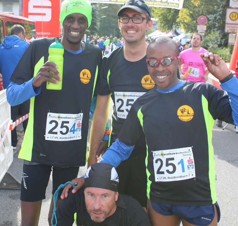 Der blinde Langstreckenlufer und mehrfache Paralympicsieger sowie Weltrekordhalter Henry Wanyoike (rechts) aus Kenia mit seinem Guide und Neffen Paul Wanyoike (links) und dem sehbehinderten Physiotherapeut Michael Pfeifer im Ziel. Foto: Privat