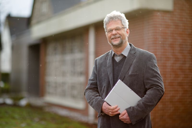 Winfried Wehrmann wird wegen seines Faibles fr Excel-Tabellen oft der "Pfarrer mit dem Laptop" genannt. Nun tritt er seinen Dienst als neuer Pfarrer in der Wirgeser Martin-Luther-Kirche (im Hintergrund) an. Foto: Peter Bongard