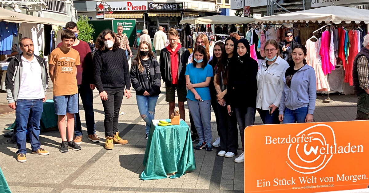 Schler der 9a der Betzdorfer Bertha-von-Suttner Realschule plus informierten sich gemeinsam mit ihrem Lehrer Carsten Winkler auf dem Wochenmarkt ber eine Ausstellung des Betzdorfer Weltladens. Es ging dabei um unfaire Handelsbeziehungen in der Welt. (Foto: Weltladen Betzdorf)