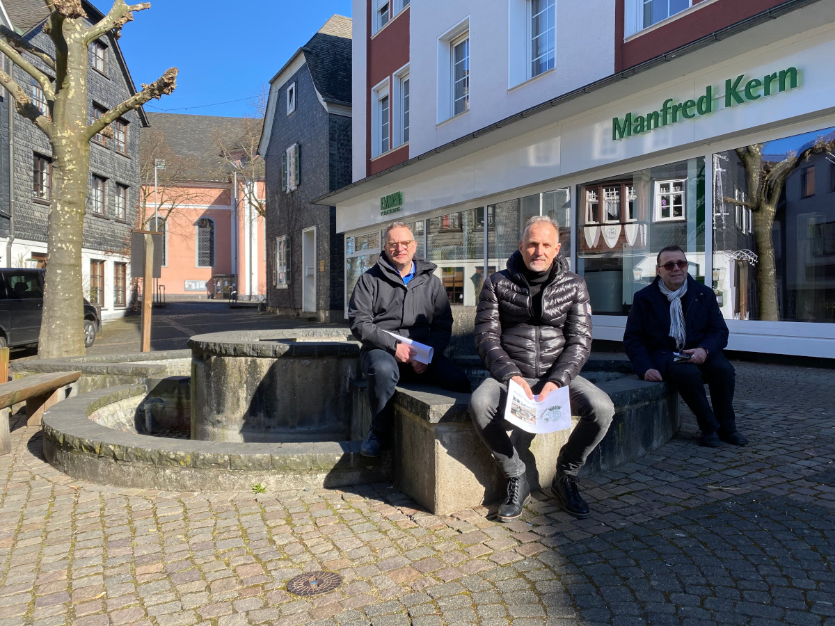 Schon jetzt gerne als Sitzgelegenheit genutzt: Der Brunnen auf dem Wissener Marktplatz. Die Planungen fr die Neugestaltung stellten Berno Neuhoff, Uli Noss und Claus Behner (von links) vor. (Foto: KathaBe) 
