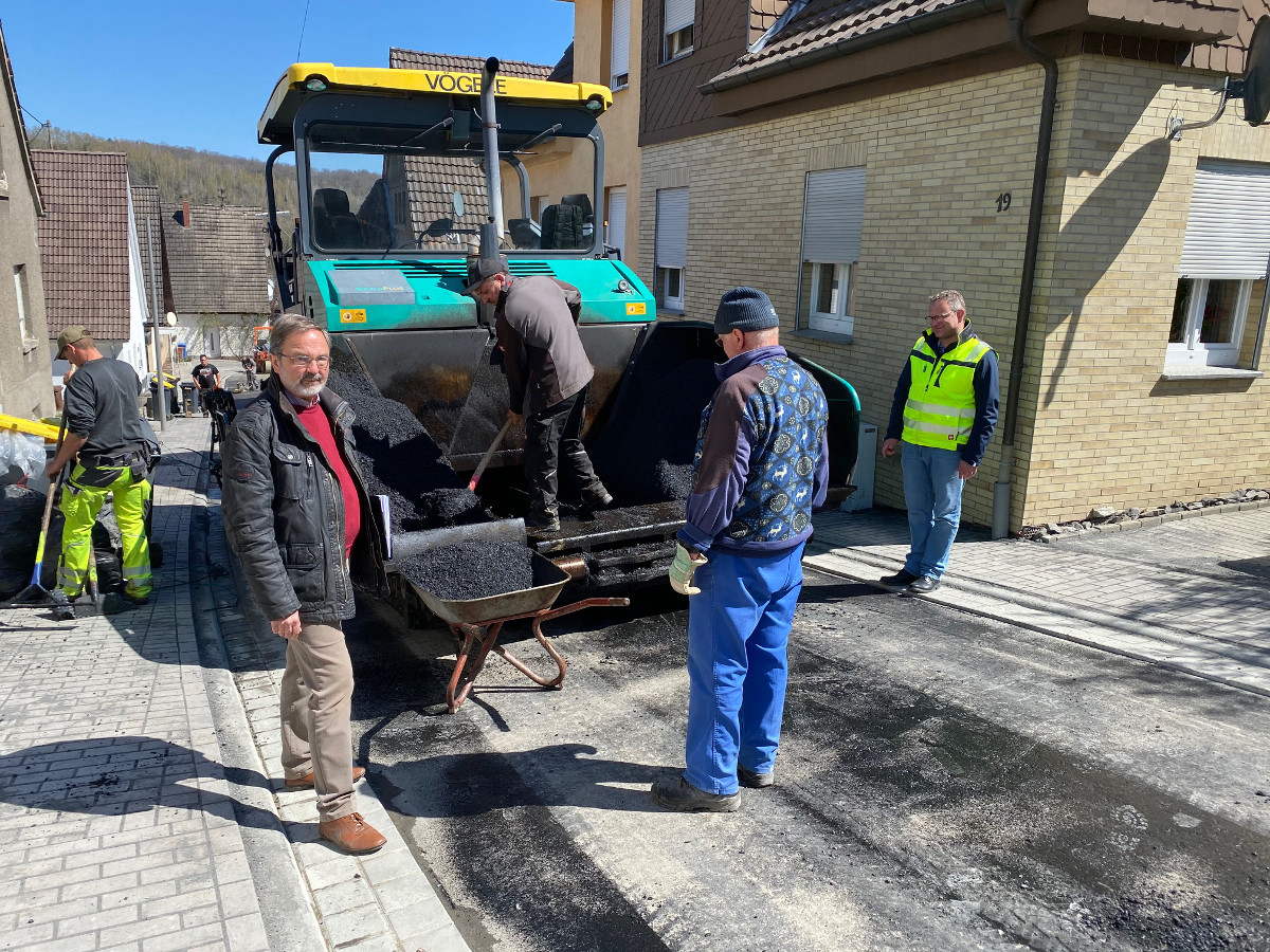 Eisen/Htten: Die letzte Asphalt-Deckschicht wird aufgebracht - dann sind Eisen- und Httenstrae fertig. Vorne links Bauingenieur Uwe Hennig und Brgermeister Berno Neuhoff (rechts). (Foto: Verwaltung)
