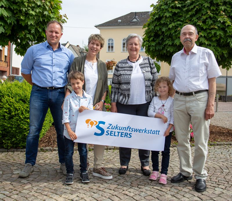 Bildunterschrift: Die Selterser Familie Chmieleck zeigt das Logo der Zukunftswerkstatt. Sie mchten sich mit drei Generationen in den Mitbestimmungsprozess einbringen. Foto: Eckhard Schneider