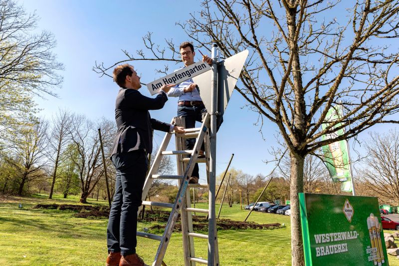 Das Foto zeigt Brgermeister Stefan Leukel und Brauereichef Jens Geimers beim Anbringen des neuen Straenschildes Am Hopfengarten. Foto: privat