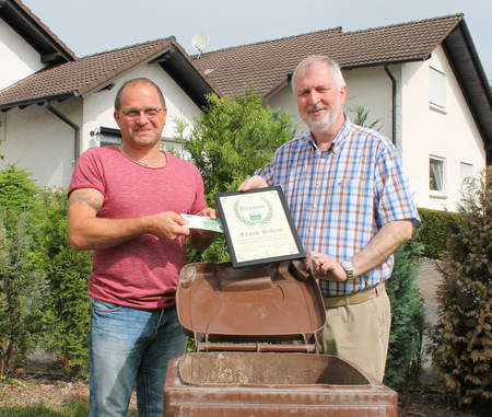 Der Erste Kreisbeigeordnete Konrad Schwan (rechts) übergab die erste Auszeichnung „Bioabfalltonne des Monats“ an Frank Schön aus Gebhardshain. (Foto: AWB)