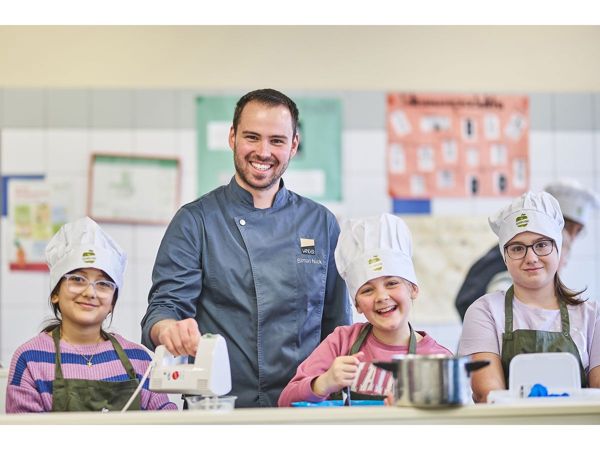 Mit Spa bei der Sache: Kanteenie-Kochprofi Simon Nick und die jungen Gewinnerinnen des Praxiskochtags an der Heinrich-Roth-Realschule Plus in Montabaur beim gemeinsamen Zubereiten des Drei-Gnge-Mens. (Foto: Sander Catering/Marc Niebling)
