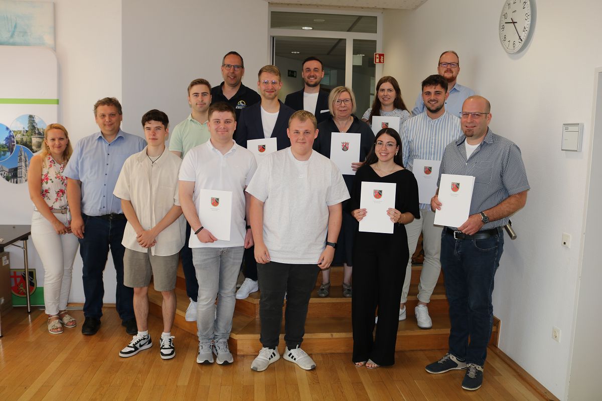 Im Kirchener Rathaus gab es anlsslich bestandener Prfungen, Ernennungen, Befrderungen und des 40. Dienstjubilums Grund zu feiern. Auf dem Foto in der 1. Reihe (v.l.): Ausbildungsleiterin Swetlana Neufeld, Broleiter Michael Dtzer, Colin Krger, Simon Rommersbach, Jonas Petznick, Lynn Brhl, Marcel Henn.
Im Hintergrund (v.l.): Niklas Bcker, Personalratsvorsitzender Alexander Grindel, Maximilian Mller, Ben Gotthardt, Jubilarin Petra Urigshardt, Ann-Christin Betz, Elias Bohl, Brgermeister Andreas Hundhausen. (Foto: VG Kirchen / K. Hinkel)