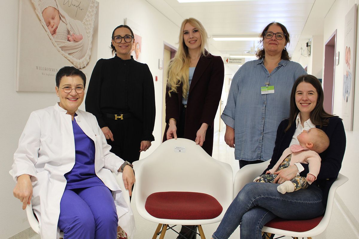 Gruppenbild mit Baby: �ber die Spende der Herkules Group � �berreicht von Viviana Voss-Thoma (sitzend rechts) und Kristina K�hler (Mitte) � freuten sich (von links) Chef�rztin Dr. Flutura Dede, Chefsekret�rin Melanie Gottwald und Hebammenleitung Bianka Bienerth. (Fotoquelle: Stefanie Brendebach, Diakonie in S�dwestfalen gGmbH)