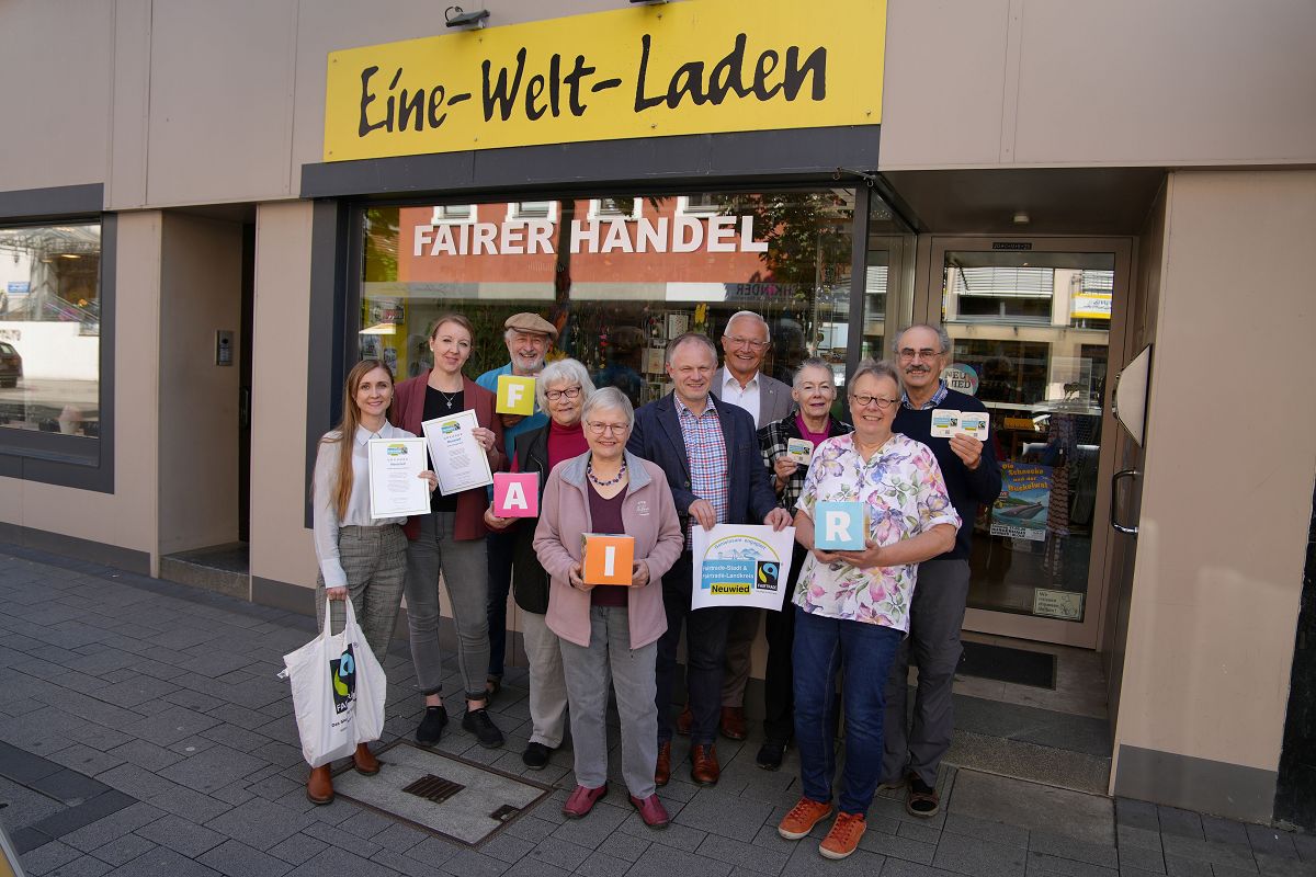 Vor dem Eine-Welt-Laden in der Neuwieder Innenstadt freuen sich Oberb�rgermeister Jan Einig, Landrat Achim Hallerbach, die Steuerungsgruppen der Fairtrade-Stadt Neuwied sowie Ehrenamtliche des Eine-Welt-Ladens, dass der Fairtrade-Town-Titel verl�ngert wurde. (Foto: Nadine Sch�neberg/Stadtverwaltung Neuwied)