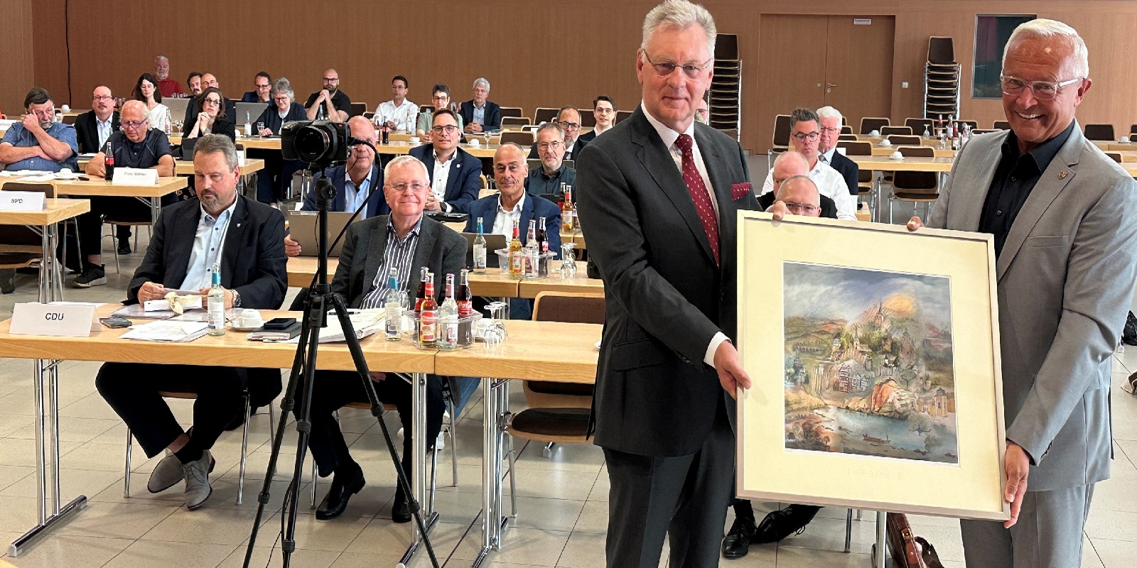 Landrat Achim Hallerbach �berreichte Viktor Schicker ein Aquarell des K�nstlers Reinhard Zado mit Motiven aus dem Landkreis Neuwied. (Foto: Thomas Herschbach)